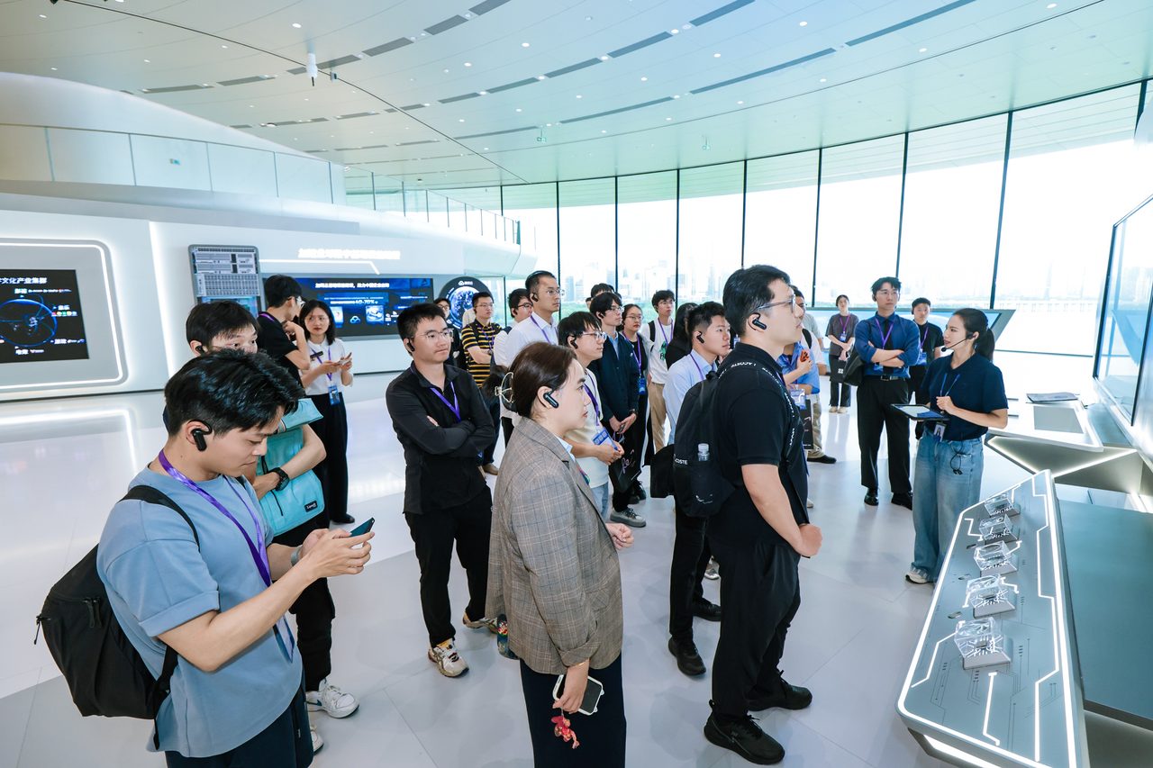 海外博士团在深圳企业展厅参访,人群围在展台前听讲解