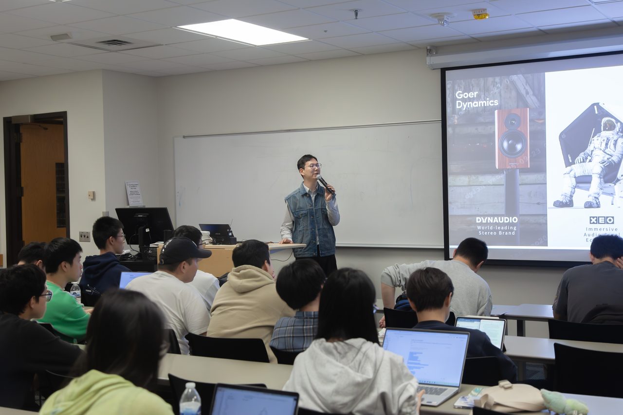 密歇根大学安娜堡分校教室内,学生坐满座位听讲,企业讲者在讲台前介绍岗位